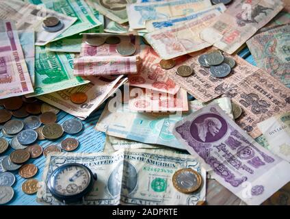 In der Nähe von alten bunten Banknoten und Münzen verschiedener Länder auf dem Tisch. Stockfoto