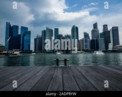 Skyline von Singapur. Die andere Perspektive auf die Marina Bay Skyline vom hölzernen Plattform mit der Promenade und der Anker im Vordergrund. Stockfoto