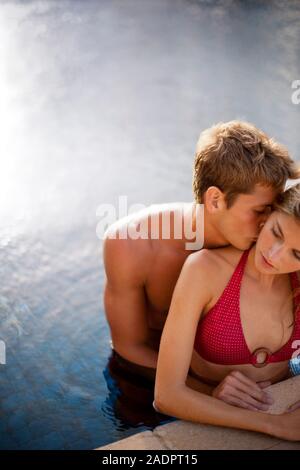 Junger Mann küsste seine Freundin während in einen Pool. Stockfoto