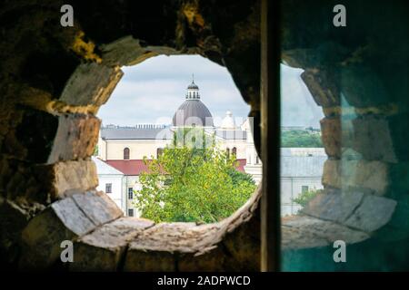 Blick durch das Fenster der Lubart Schloss mit einer Reflexion über die katholische St. Peter und Paul Kathedrale oder Jesuitenkirche in Lutsk, Ukraine Stockfoto
