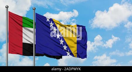 Vereinigte Arabische Emirate und Bosnien und Herzegowina Flagge im Wind gegen Weiße bewölkt blauer Himmel zusammen. Diplomatie Konzept, Internationale Beziehungen Stockfoto