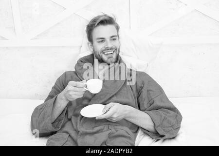 Ab Tag mit guten Kaffee. Entspannt zu Hause. Angenehme Momente. Gourmet Espresso. Kaffee am Morgen genießen. Gerne morgen. Schöner Mann trinken Kaffee am Morgen. Happy bärtiger Mann im Bett. Gute Laune. Stockfoto
