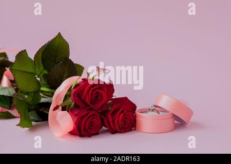 Hochzeit Ringe und Hochzeit Strauß roter Rosen auf Holztisch, horizontal selektiven Fokus, der Hintergrund ist unscharf Stockfoto