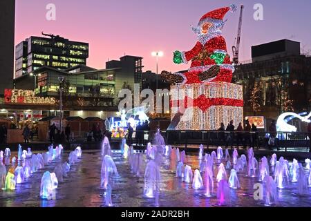 Merry Christmas, aus Piccadilly Gardens, Manchester, England, Großbritannien, M1 1RN Uhr - Weihnachtsmann in der Abenddämmerung Stockfoto