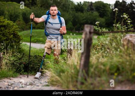 Sicher Mann mit Prothese mit einem Nordic walking Training Stockfoto