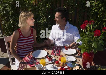 Das junge Paar frühstückt im Freien- ein junges Paar, das Frühstück im Freien Stockfoto