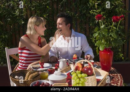 Das junge Paar frühstückt im Freien- ein junges Paar, das Frühstück im Freien Stockfoto