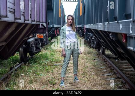 Ein Mädchen in einem grünen Anzug geht hinunter die Straße indastrial Stockfoto