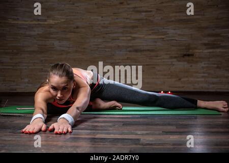 Ruhige junge Dame Yoga und Stretching auf der Yogamatte Stockfoto