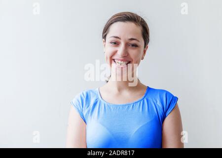 Beauty Portrait Junge glücklich positive lächelnde Frau, T-Shirt farbig in Trendfarbe des Jahres 2020 Classic Blau auf weißem Hintergrund. Helle Mac Stockfoto