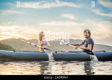 Mann und Frau schwimmt auf Kajak im Meer auf der Insel. Kajak Konzept. Kajak Konzept mit Familie Vater Mutter auf See Stockfoto