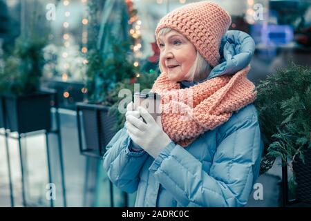 Nachdenklich Rentner genießen Kaffee draußen im kalten Tag Stockfoto