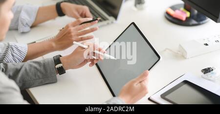 7/8 Schuß des Young Professional UX Web developer Team auf ihr Projekt gemeinsam mit Tablet Stockfoto