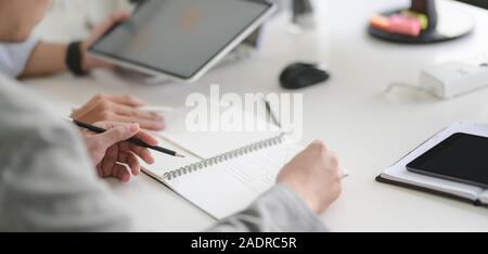 7/8 Schuß des Young Professional UX Web developer Team auf ihr Projekt gemeinsam mit Tablet Stockfoto