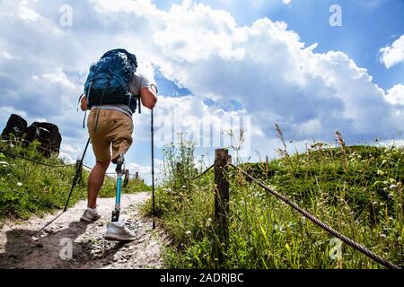 Rückansicht eines bestimmten behinderten Mann, der versucht, Nordic Walking Stockfoto