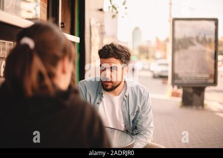 Paar sprechen während der Sitzung im Straßencafé Stockfoto