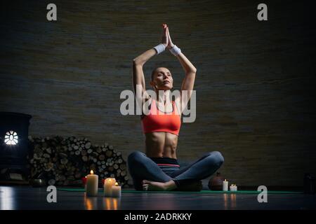Volle Länge des friedlichen Frau in Yoga sitting Pose Stockfoto
