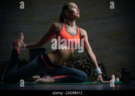 Sportliche Frau suchen, während ihre Beine Stretching und Yoga Stockfoto