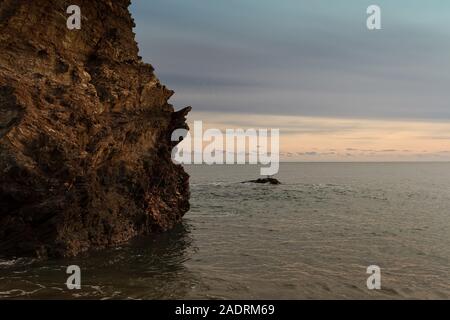 Zwei Möwen auf einem Stein saß von einem Felsen am Strand von Cornwall, Großbritannien. Die Wellen sind das Waschen der Felsen und die Möwen haben eine harte Zeit Stockfoto