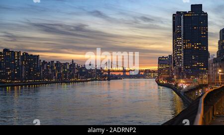 Auf der Suche nach Süden entlang des East River in Richtung 59th Street Bridge, in der Upper East Side von Manhattan bei Sonnenuntergang Stockfoto