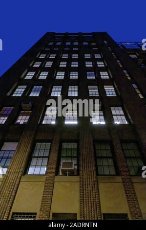 Blick auf die Fassade eines großen Backsteingebäude an der Upper East Side von Manhattan bei Nacht, New York City Stockfoto