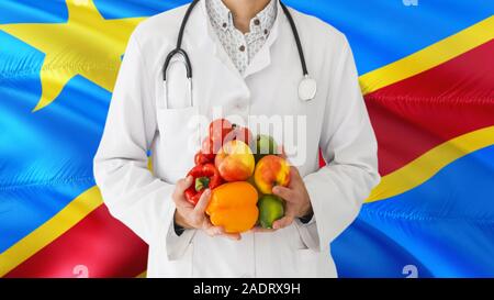 Arzt hält Sie Obst und Gemüse in die Hände mit dem Kongo Flagge Hintergrund. Nationalen Gesundheitswesen Konzept, medizinische Thema. Stockfoto