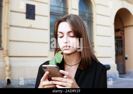 Das Mädchen sendet eine Nachricht von Ihrem Smartphone Stockfoto