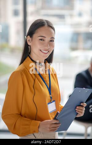 Junge hübsche asiatische Frau mit einem Abzeichen schön lächeln Stockfoto