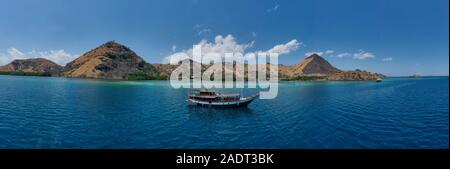 Schöne Aussicht die Manjaja Fischerdorf und Saloka Insel mit Blau und grean Ozean und traditionellen hölzernen Steg in Labuan Bajo, Indones entfernt Stockfoto