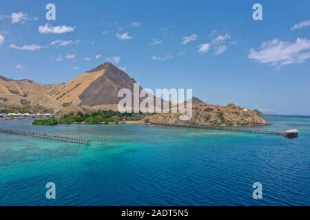 Schöne Aussicht die Manjaja Fischerdorf und Saloka Insel mit Blau und grean Ozean und traditionellen hölzernen Steg in Labuan Bajo, Indones entfernt Stockfoto