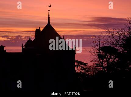 Lyme Regis, Dorset, Großbritannien. 5. Dezember 2019. UK Wetter: Schöne winter Sonnenaufgang in Lyme Regis. Gebäude und Bäume sind gegen die wunderschöne Farben im Himmel auf einer kühlen Morgen. Credit: Celia McMahon/Alamy Leben Nachrichten. Stockfoto