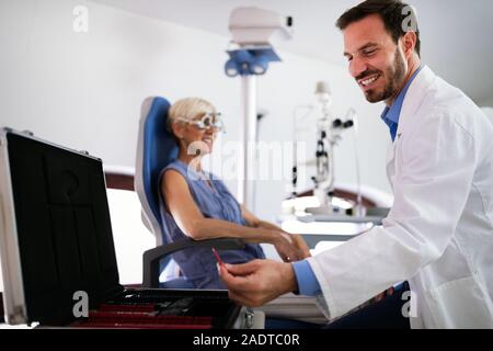 Optiker Prüfung der älteren Frau in der modernen Augenheilkunde Klinik Stockfoto