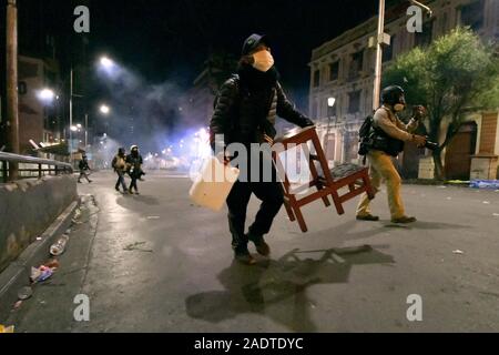 La Paz, La Paz, Bolivien. 12 Nov, 2019. Auseinandersetzungen in La Paz/Bolivien. Eine Schuhputzmaschine/-arbeiter Flucht von Tränengas. Auseinandersetzungen mit der Polizei während der Unruhen zwischen pro- und anti Evo Morales Demonstranten. Demonstranten haben auf den Straßen in Bolivien nach der Auszählung der Stimmen auf Oktober 2019 Präsidentschaftswahlen in Kontroverse über einen massiven Betrug aus dem Evo Morales mas Party abgestiegen. die Opposition im Land die Regierung von Präsident Evo Morales beschuldigt hat von Betrug nach der Zählung wurde auf mysteriöse Weise für 24 Stunden, während die Stimmen zählen und verweist auf die Notwendigkeit einer Dec ausgesetzt Stockfoto