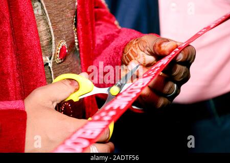 Schneiden Farbband im indischen Hochzeit rituellen Begrüßungszeremonie Stockfoto