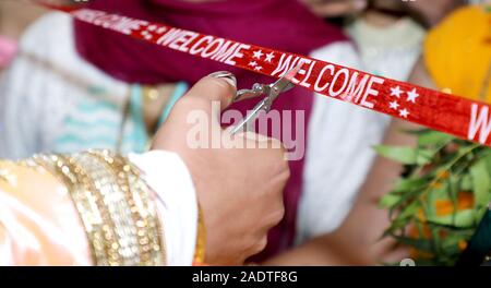 Schneiden Farbband im indischen Hochzeit rituellen Begrüßungszeremonie Stockfoto