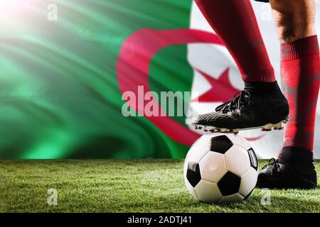 Nahaufnahme Beine von Algerien Fußball Team Player in roten Socken, Schuhe auf Fußball im Free Kick oder elfmeterpunkt Spielen auf Gras. Stockfoto