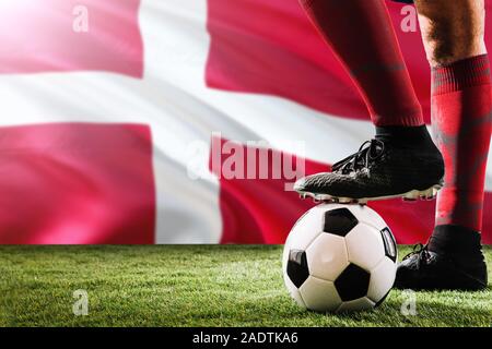 Nahaufnahme Beine von Dänemark Fußballmannschaft Spieler in roten Socken, Schuhe auf Fußball im Free Kick oder elfmeterpunkt Spielen auf Gras. Stockfoto