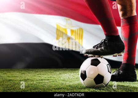 Nahaufnahme Beine in Ägypten Fußball Team Player in roten Socken, Schuhe auf Fußball im Free Kick oder elfmeterpunkt Spielen auf Gras. Stockfoto