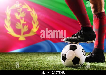 Nahaufnahme Beine von Eritrea Fußballmannschaft Spieler in roten Socken, Schuhe auf Fußball im Free Kick oder elfmeterpunkt Spielen auf Gras. Stockfoto