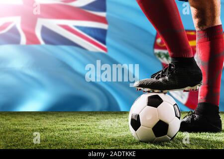 Nahaufnahme Beine von Fidschi Fußballmannschaft Spieler in roten Socken, Schuhe auf Fußball im Free Kick oder elfmeterpunkt Spielen auf Gras. Stockfoto