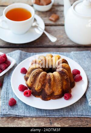 Schokolade Marmor bundt Cake mit einer Tasse Tee auf hölzernen Hintergrund Stockfoto