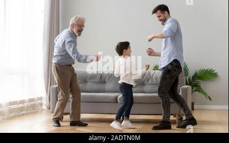 In voller Länge drei Generationen von Männern tanzen im Wohnzimmer. Stockfoto