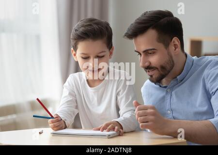 Vater hilft, kleinen Sohn lehrt mit Bleistift zu zeichnen Stockfoto