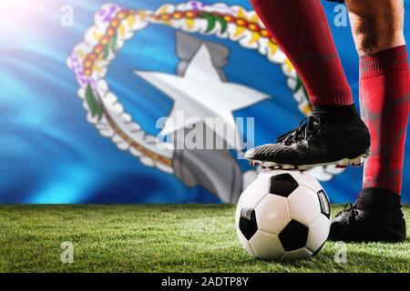 Nahaufnahme Beine von Nördliche Marianen Fußballmannschaft Spieler in roten Socken, Schuhe auf Fußball im Free Kick oder elfmeterpunkt Spielen auf Gras. Stockfoto