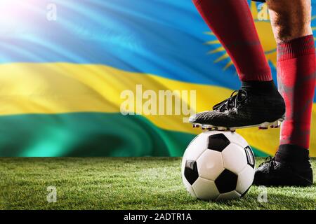 Nahaufnahme Beine von Ruanda Fußballmannschaft Spieler in roten Socken, Schuhe auf Fußball im Free Kick oder elfmeterpunkt Spielen auf Gras. Stockfoto