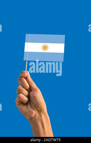 Frau hand Argentinien Fahne mit Stock, wehende Flagge auf tief blauen Himmel. Die nationalen Thema, tief blauen Himmel. Stockfoto