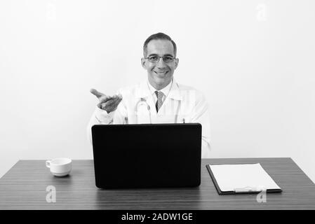 Reifen persischen Mann Arzt hinter dem Schreibtisch in Schwarz und Weiß Stockfoto