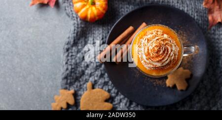 Kürbis Latte mit Gewürzen. Versoffenes Cocktail mit Schlagsahne. Grauer Hintergrund. Kopieren Sie Platz. Ansicht von oben Stockfoto