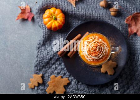 Kürbis Latte mit Gewürzen. Versoffenes Cocktail mit Schlagsahne. Grauer Hintergrund. Ansicht von oben Stockfoto