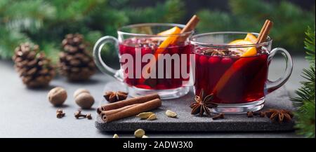 Glühwein Rotwein mit Gewürzen. Weihnachtsdekoration. Grauen Stein Hintergrund. Nahaufnahme Stockfoto